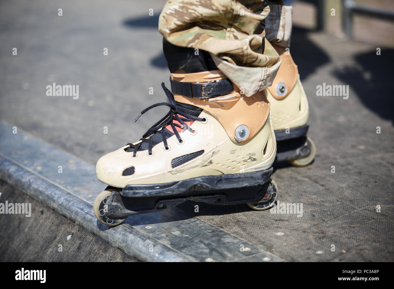 Aggressive inline roller blader wearing big yellow skates for extreme skating.Feet of young