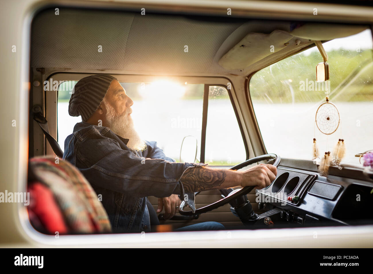 Senior hipster driving a van by countryside Stock Photo