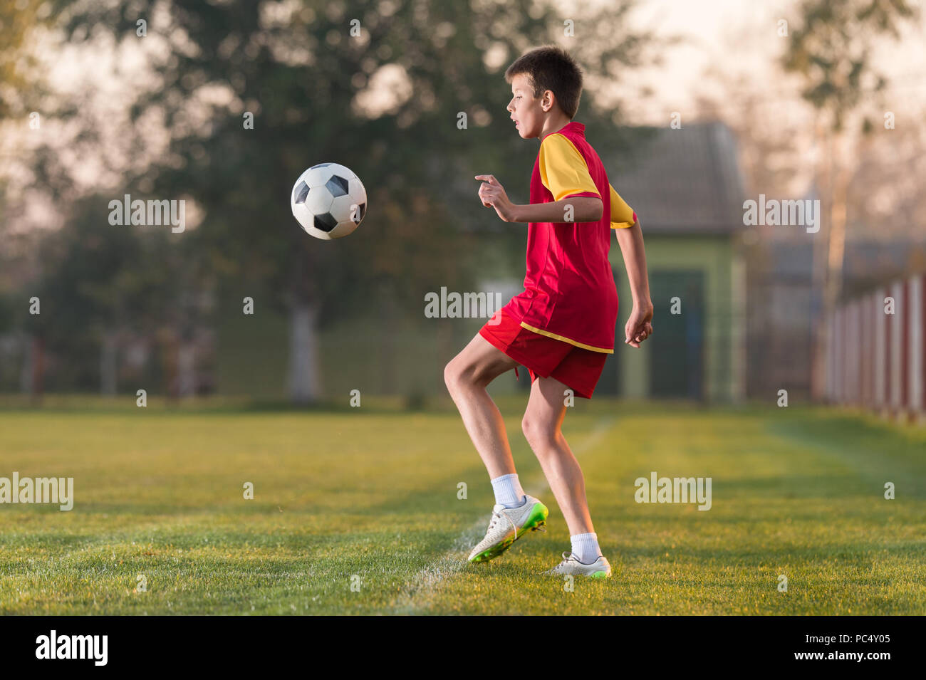 Child playing football on a soccer field Stock Photo - Alamy