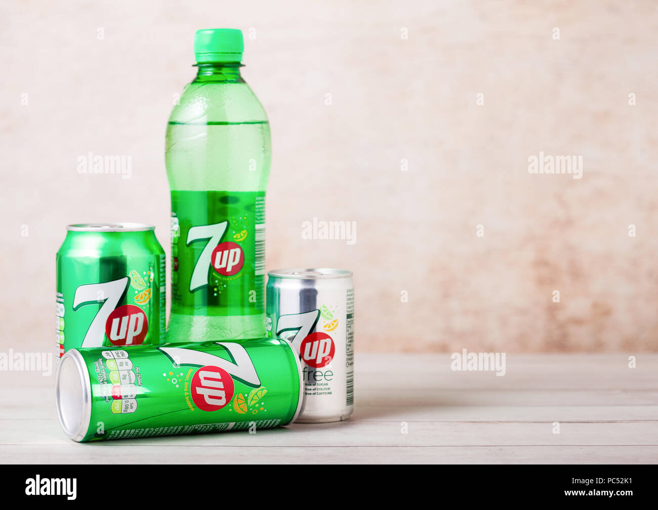 LONDON, UK - AUGUST 03, 2018: Plastic bottle and aluminium cans of 7UP citrus soda drink on wood. Stock Photo