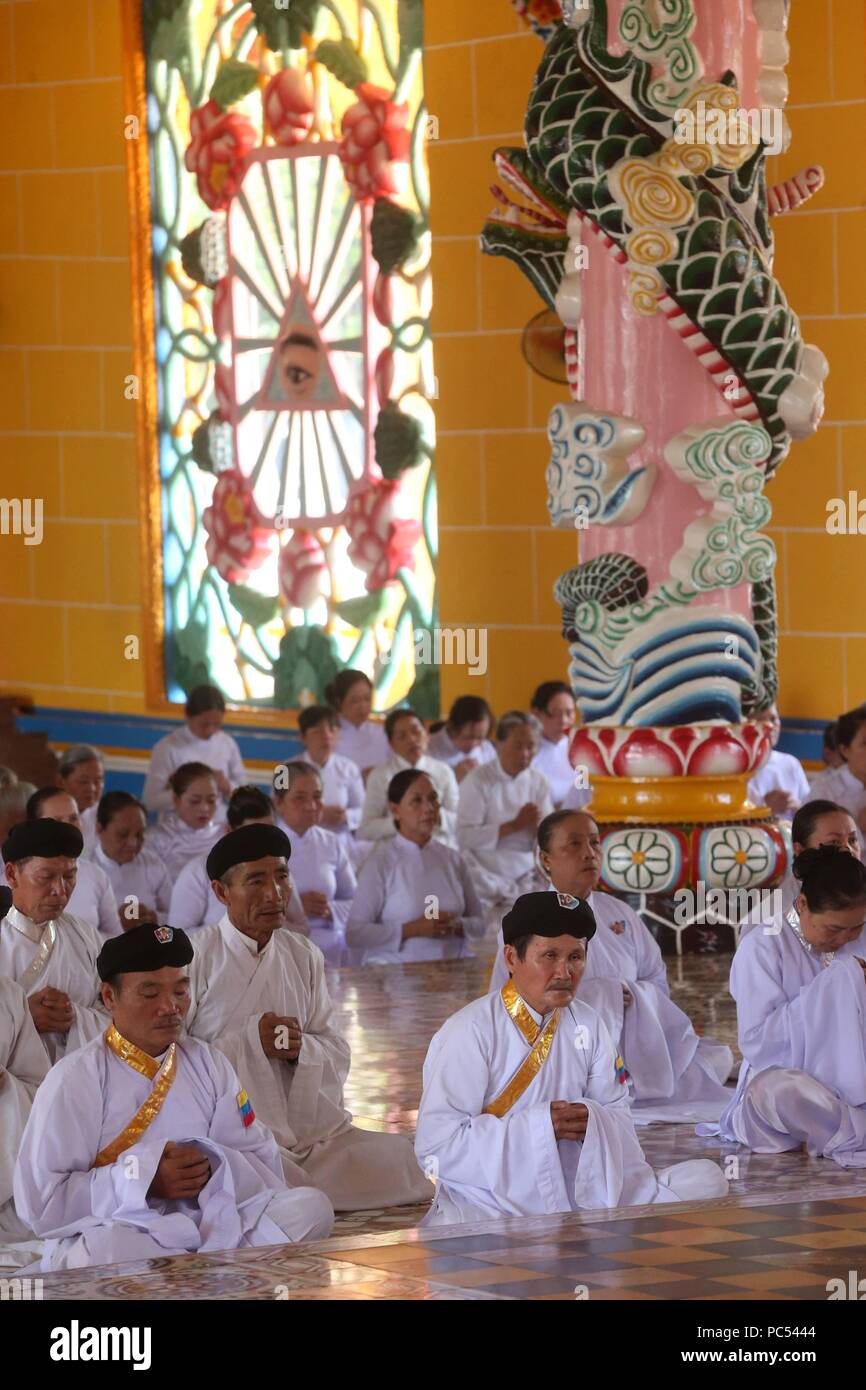 Cao Dai Holy See Temple. Praying devout men, ceremonial midday prayer ...