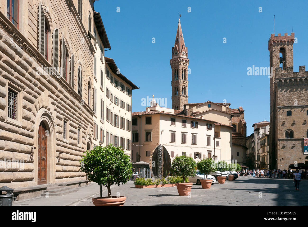 Medieval architecture in a plaza, with a church steeple in the background, in Florence, Italy Stock Photo