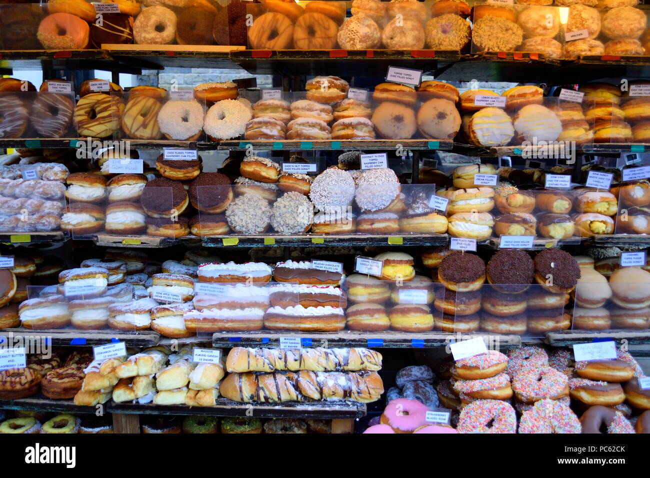 Various doughnuts displayed on the shelves in Camden Market Stock Photo