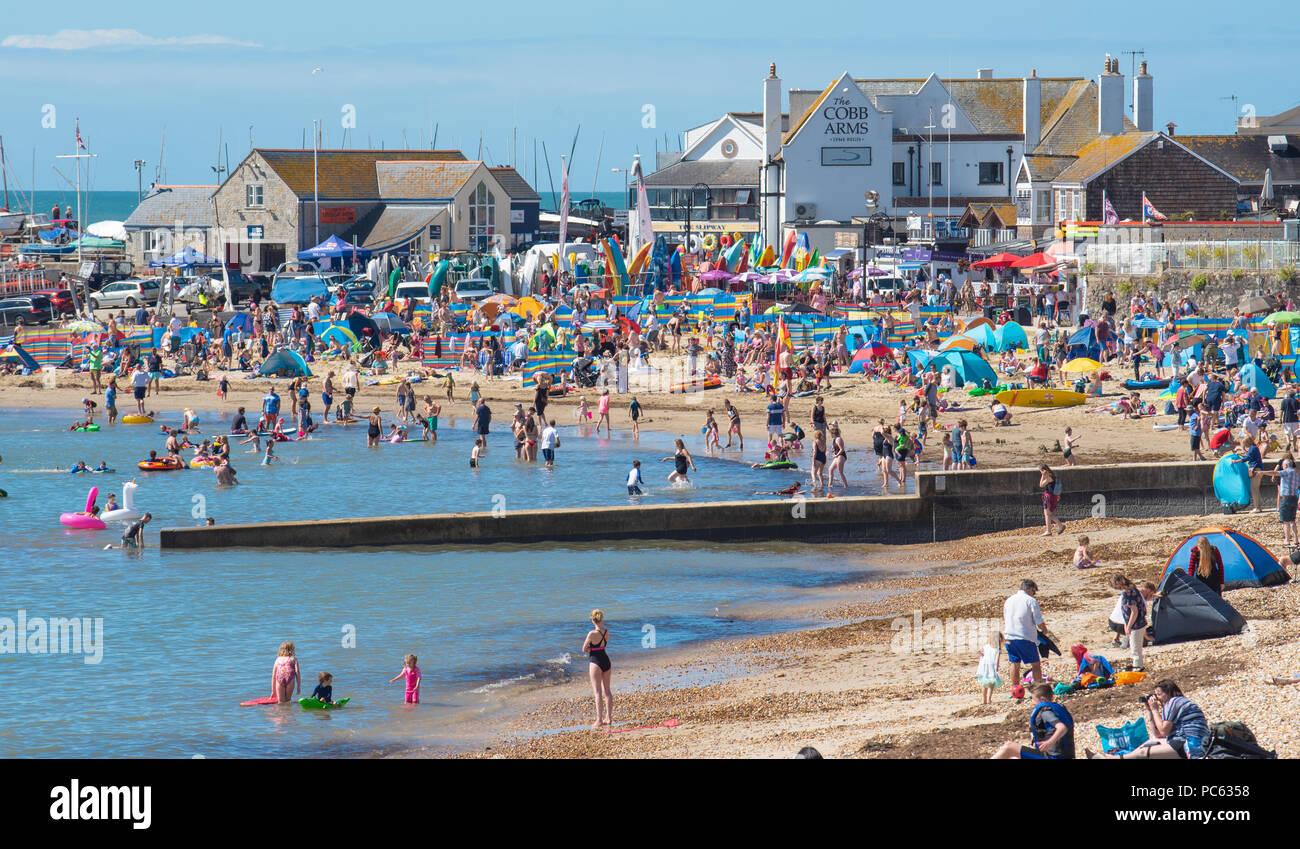Lyme Regis, Dorset, UK. 31st July 2018.  UK Weather:  Hot sunshine and blue sky returns to Lyme Regis. Holidaymakers flock back to the picturesque beach at the seaside resort of Lyme Regis to enjoy the return of the summer heatwave. Temperatures are set to rise across the UK once again this week. Credit: Celia McMahon/Alamy Live News Stock Photo