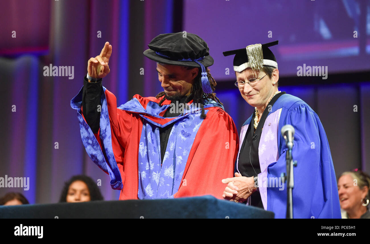Brighton UK 31st July 2018 - The renowned rapper and writer Akala receives a Doctor of Arts in recognition of his major contribution to empowering young people through learning at the University of Brighton Graduation ceremony today . The award was presented by Professor Debra Humphris the Vice-Chancellor of the University of Brighton Credit: Simon Dack/Alamy Live News Stock Photo