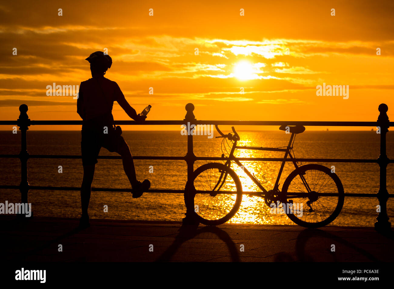 Mountain biker silhouetted at sunrise. UK Stock Photo