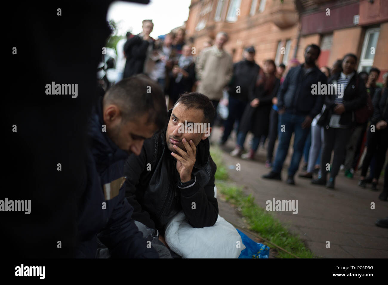 Glasgow, Scotland, on 1 August 2018. Rally in support of refugees facing eviction by private housing company SERCO. SERCO announced this week that they would begin to evict asylum seekers who have had their application for refugee status rejected. Up to 300 refugees are facing imminent eviction, including Afghan refugees Rahman Shah and Mirwais Ahmadzai (both pictured, bottom left) who have gone on hunger strike outside a Home Office building in Glasgow. Image credit: Jeremy Sutton-Hibbert/ Alamy News Stock Photo