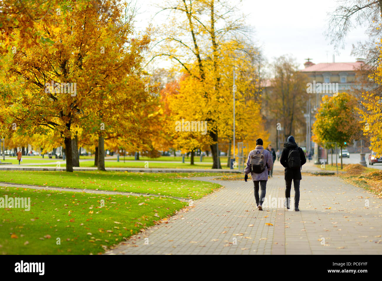 People walking down the streets of Vilnius Old Town. Beautiful sunny autumn day in the capital of Lithuania. Stock Photo