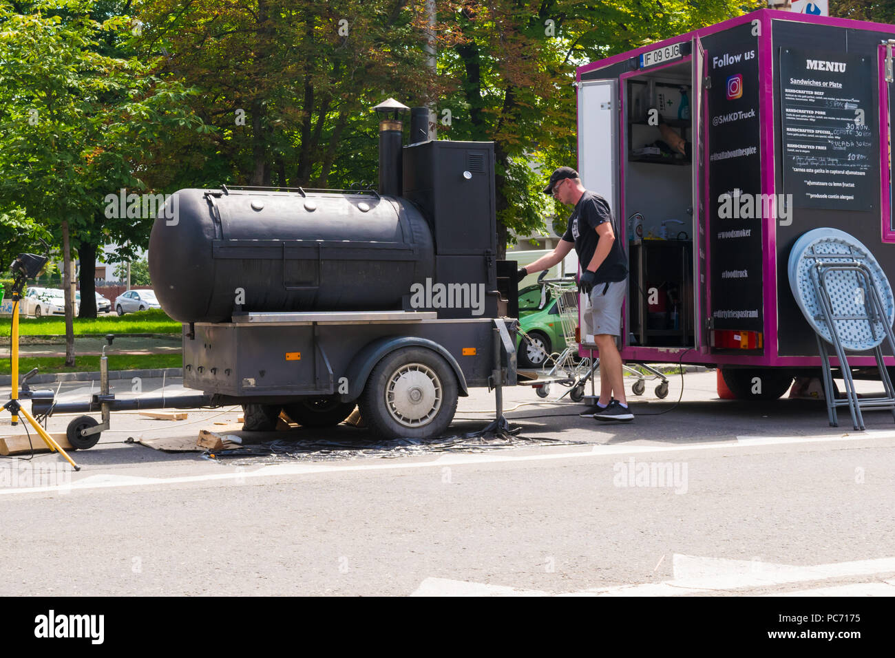 Ploiesti, Romania - July 14, 2018: Man attends barbecue / oven in shape of train locomotive at The Medieval Festival held in Ploiesti, Prahova, Romani Stock Photo