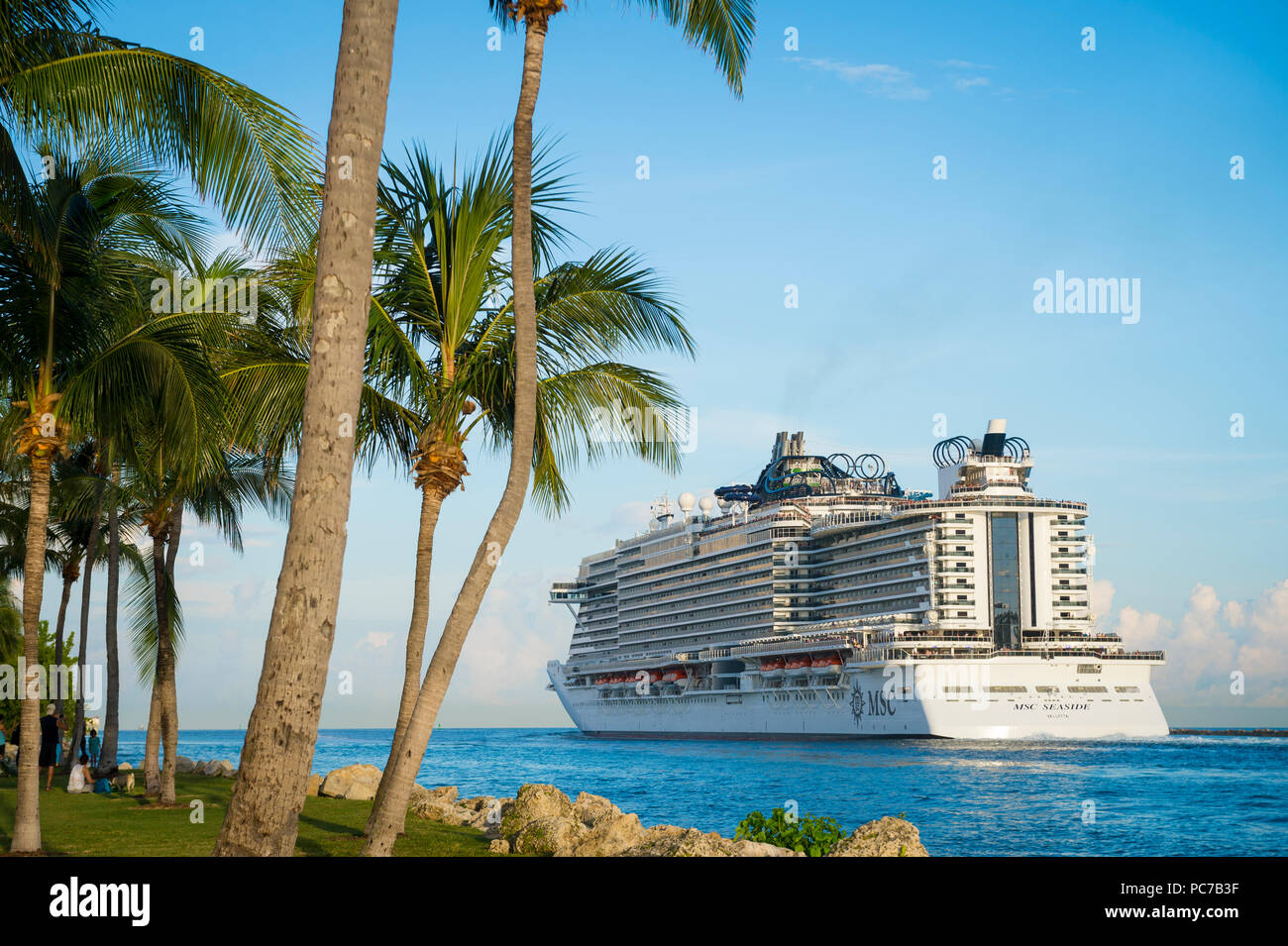 MIAMI - CIRCA JUNE, 2018: MSC Seaside cruise ship passes South Beach palm trees as it leaves port. Stock Photo