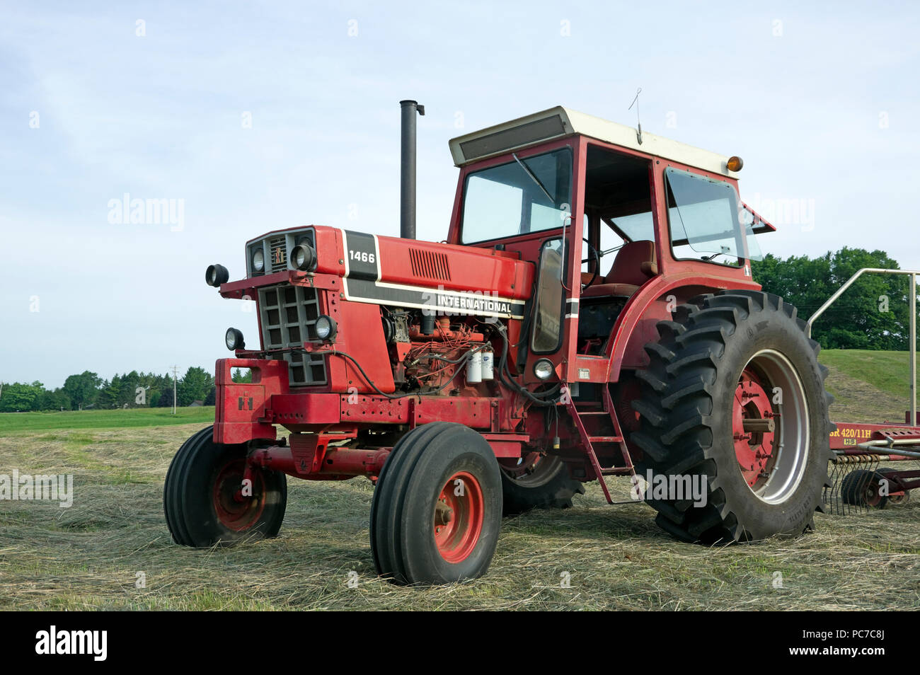 International Harvester model 1466 diesel Row Crop tractor in hay field Stock Photo