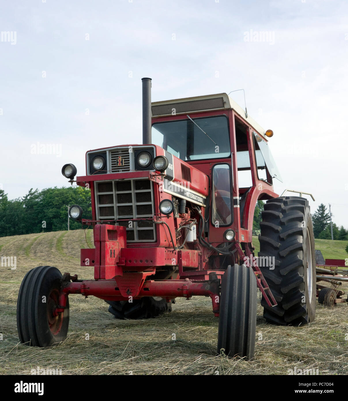 International Harvester model 1466 diesel Row Crop tractor in hay field Stock Photo