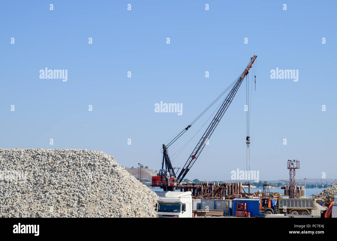 Crimean bridge, Taman, Russia - July 9, 2018: Construction of the Crimean bridge. Piles of rubble and cranes lifted. Construction and repair. Driving  Stock Photo
