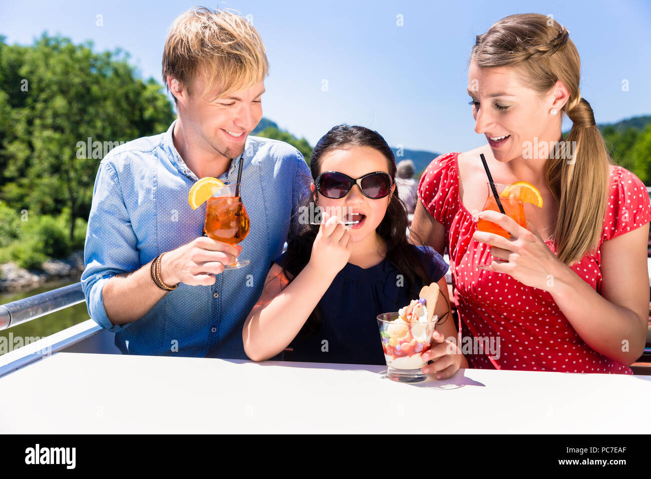 Family at lunch on river cruise with beer glasses on deck Stock Photo