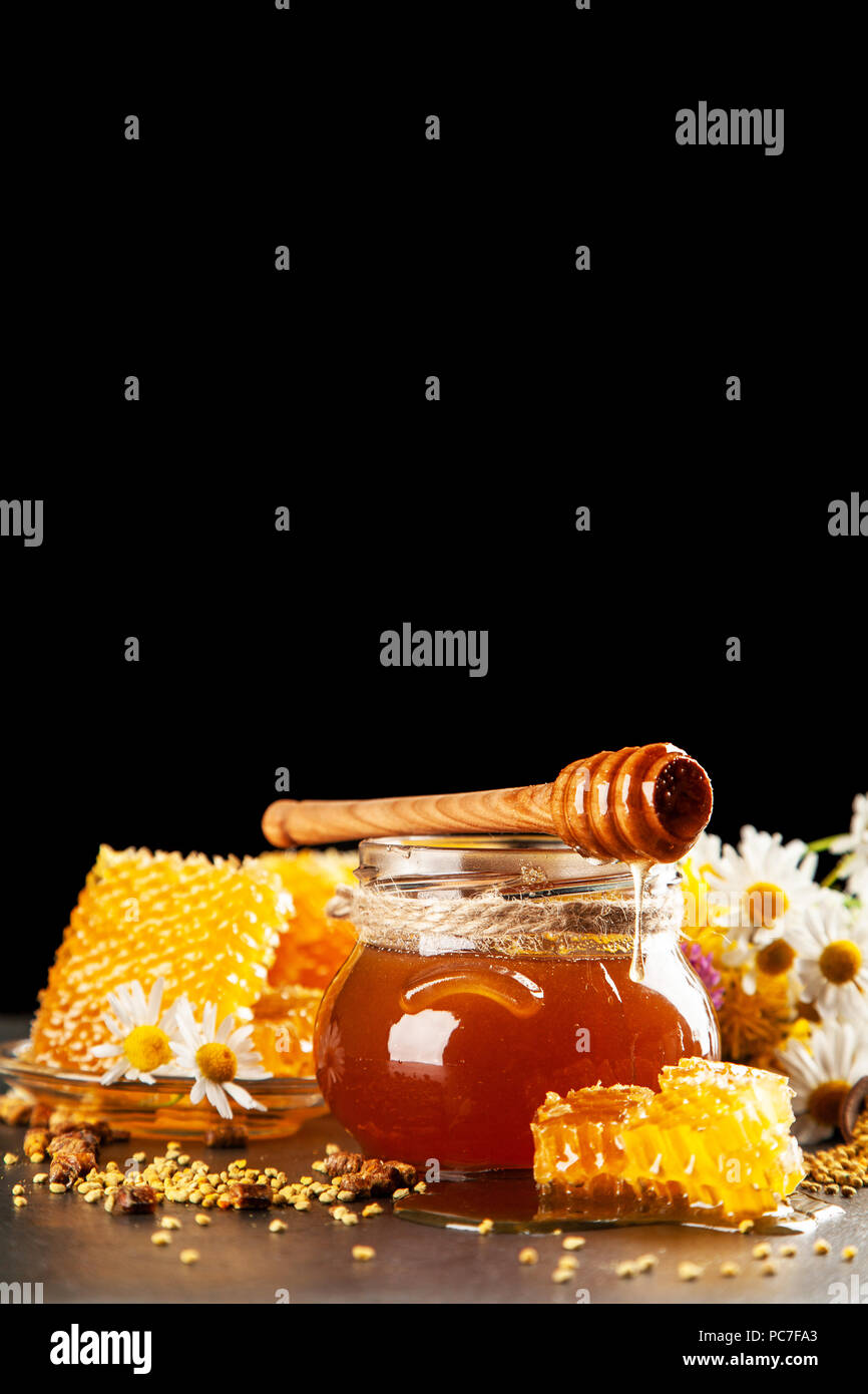 Honey jar and dipper with leaking honey Stock Photo Alamy