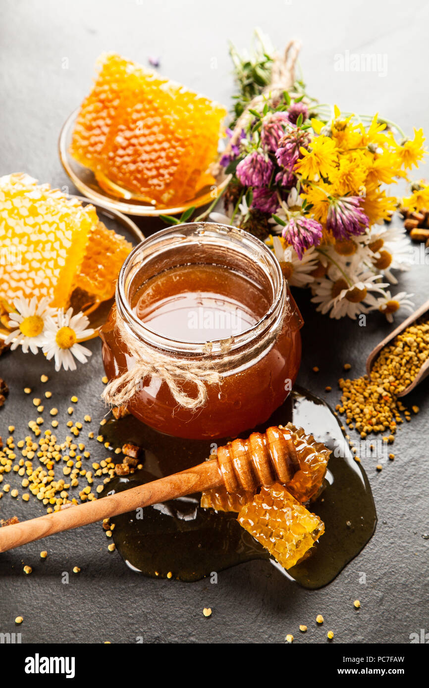 Honey jar and dipper with leaking honey Stock Photo Alamy