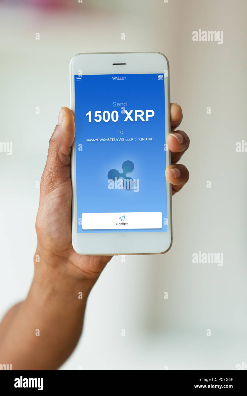 African american person sending a ripple xrp crypto transaction using  mobile phone wallet - Black people Stock Photo - Alamy