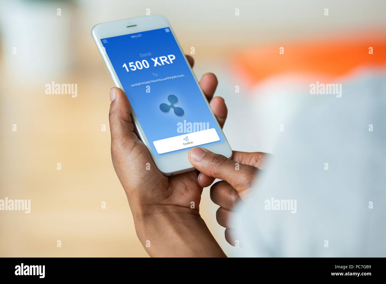 African american person sending a ripple xrp crypto transaction using  mobile phone wallet - Black people Stock Photo - Alamy