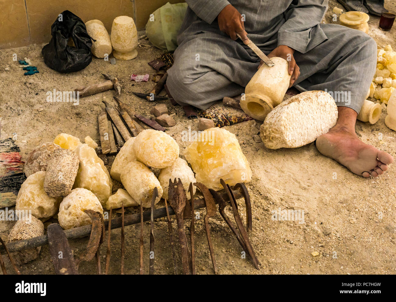 Egyptian workman using carving tool to carve alabaster container in workshop for tourist souvenirs, West Bank, Luxor, Egypt, Africa Stock Photo