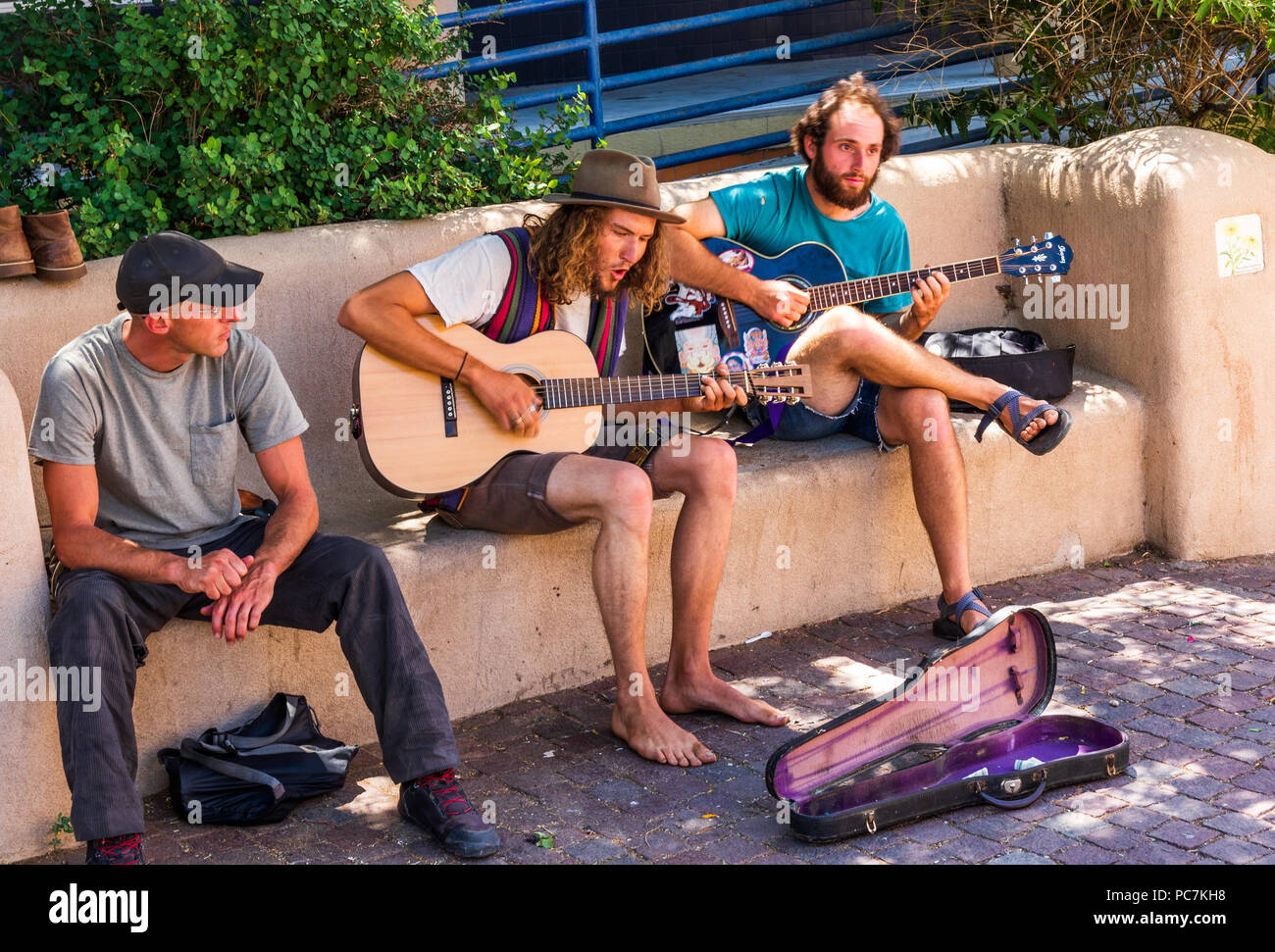 TAOS, NM, USA-8 JULY 18:  Two guitarists and a fiddler sit on Bent St., playing for tips. Stock Photo