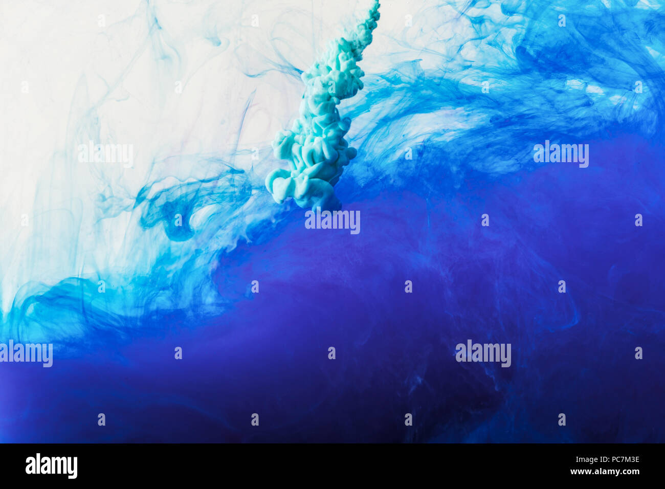 abstract background with flowing blue and turquoise paint in water ...