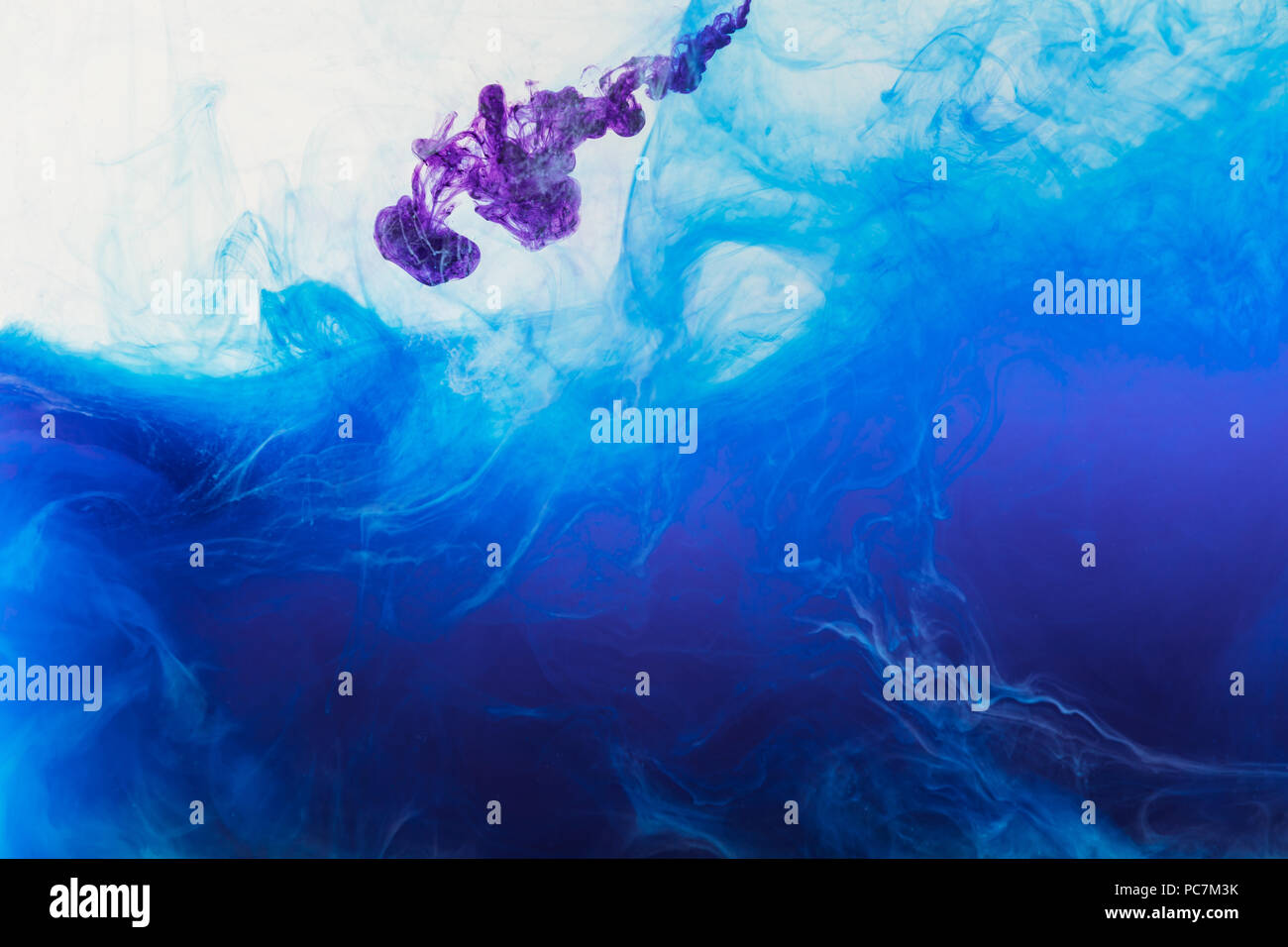 blue and purple paint mixing in water Stock Photo - Alamy