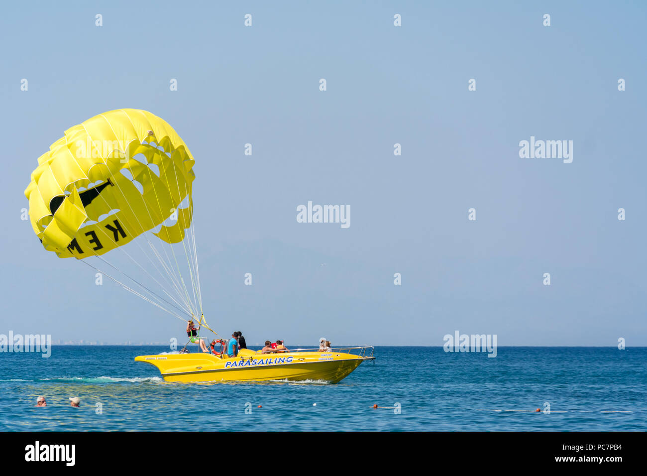 An adventure seeking holiday maker about to take off by parachute for some parasailing fun behind a purpose built speed boat. Stock Photo