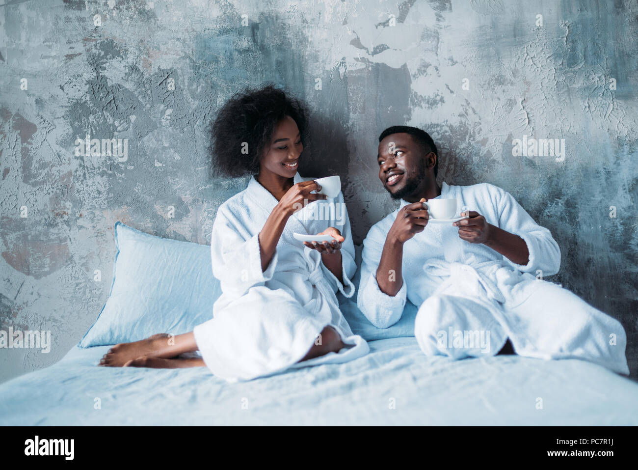 Young african american couple in bed with cups of coffee Stock Photo ...