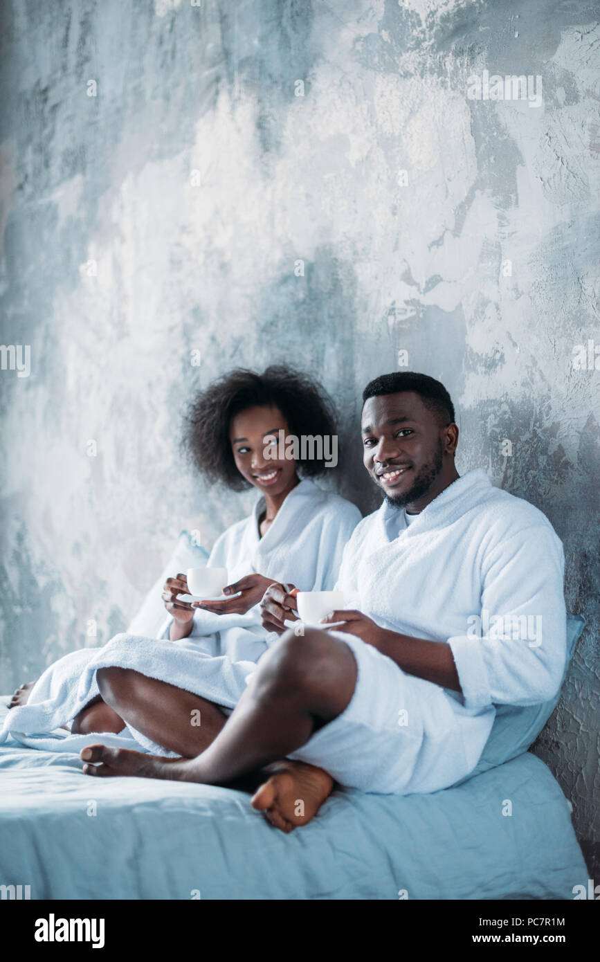 Smiling african american couple in bed with cups of coffee Stock Photo ...