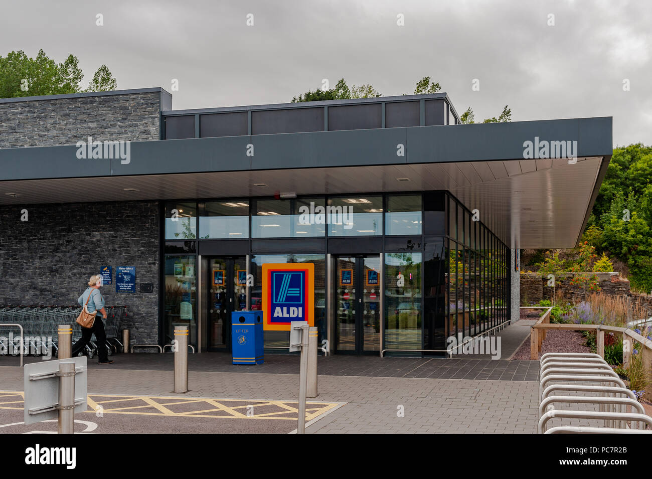 Woman walking into Aldi discount Supermaket in Skibbereen, West Cork, Ireland with copy space. Stock Photo