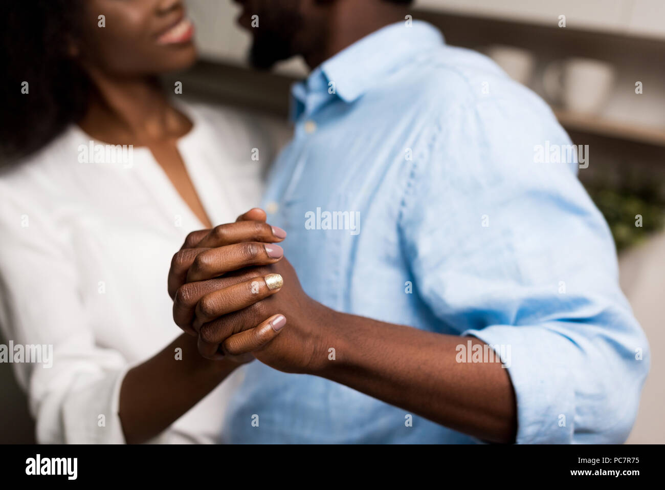 Cropped image of smiling african american couple holding each other hands Stock Photo