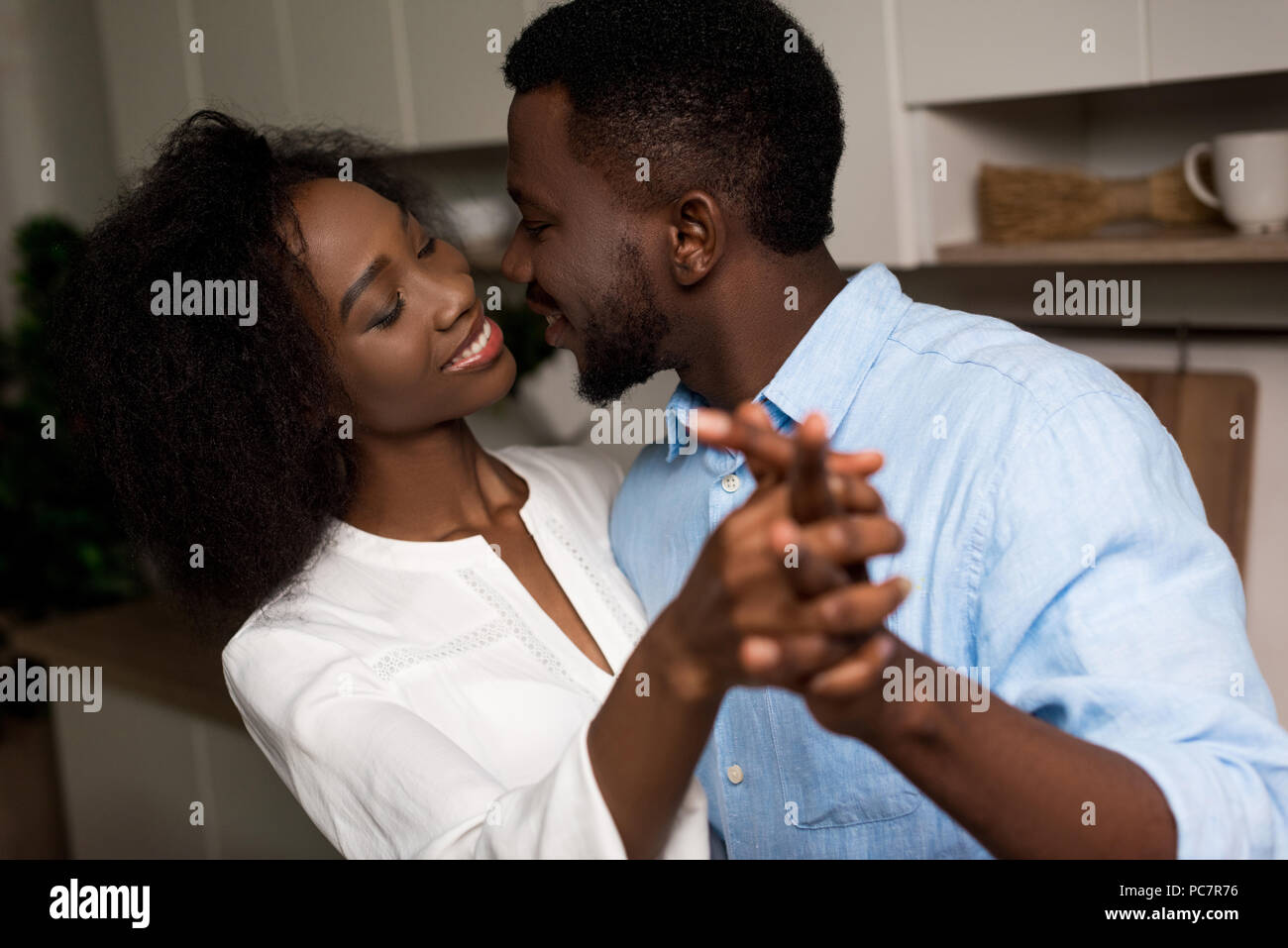Smiling african american couple holding each other hands Stock Photo