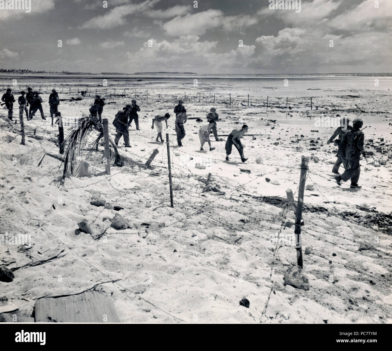 Japanese prisoners taken by Marines in stooped position to prevent ...
