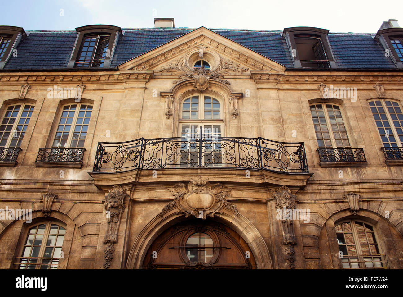 View of a traditional, historical building in Paris showing Parisian / French architectural style. It is a sunny day in spring. 3rd arrondissement Stock Photo