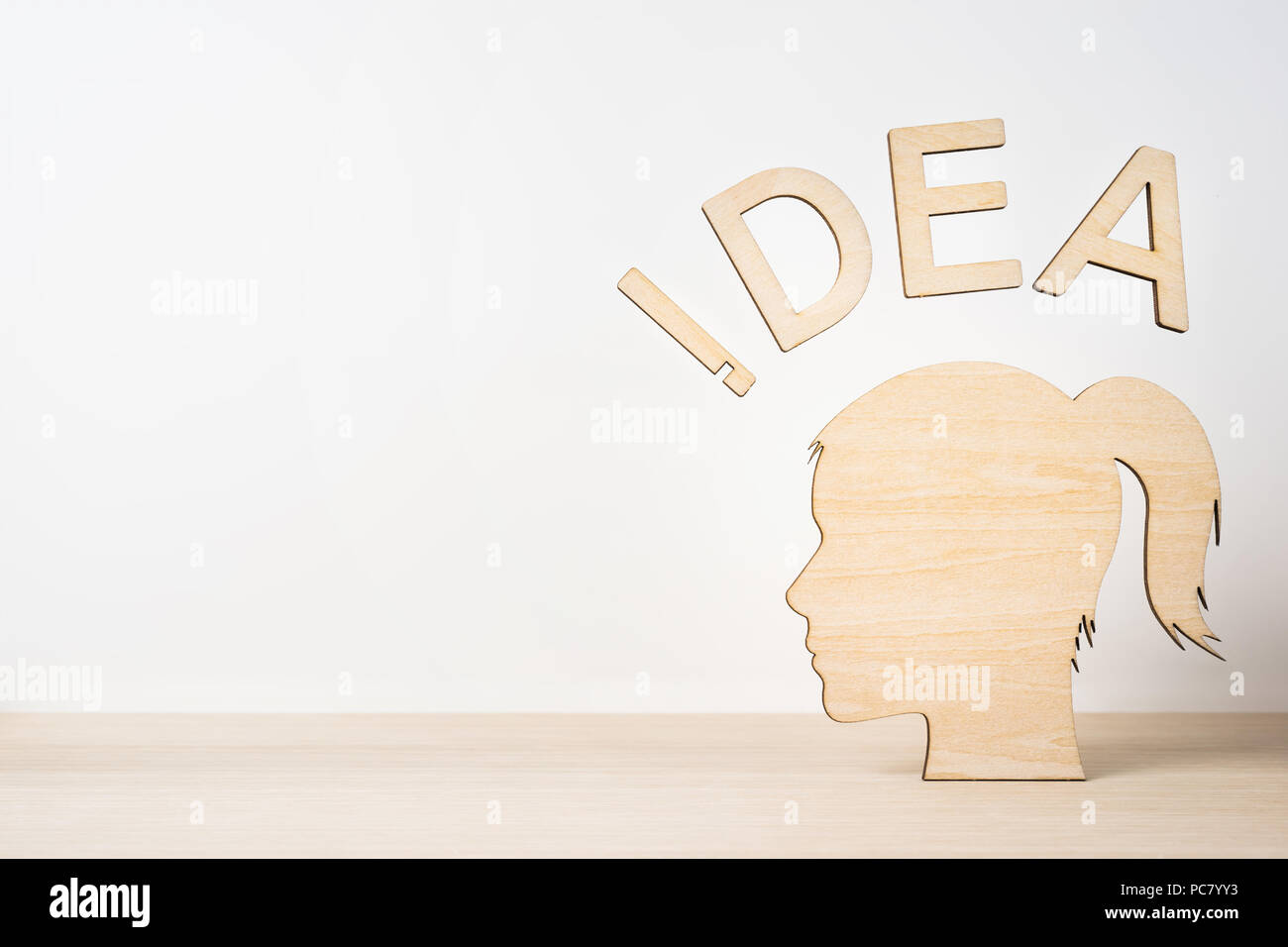 Business and design concept - wooden girl silhouette head with word ' IDEA ' on wooden desktop and white background Stock Photo