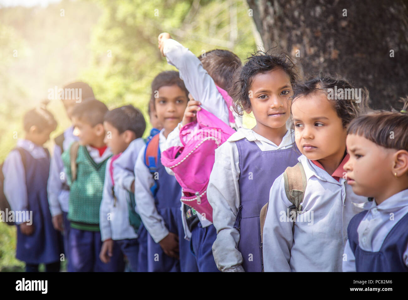 Village elementary school kids forming line for morning prayer. different age group children wearing school uniform. Stock Photo