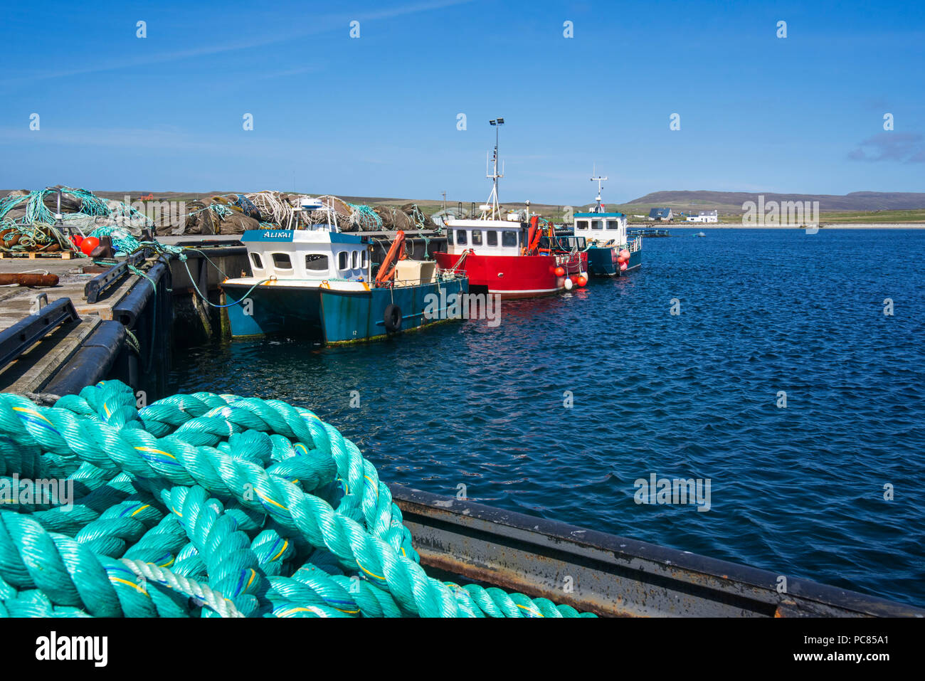 Fish farming workboats in the harbour of Uyeasound on the Isle of Unst, Shetland Islands, Scotland, UK Stock Photo