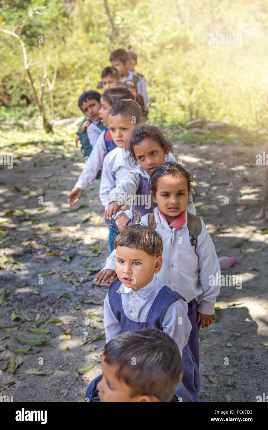 Village elementary school kids forming line for morning prayer. different age group children wearing school uniform. Stock Photo