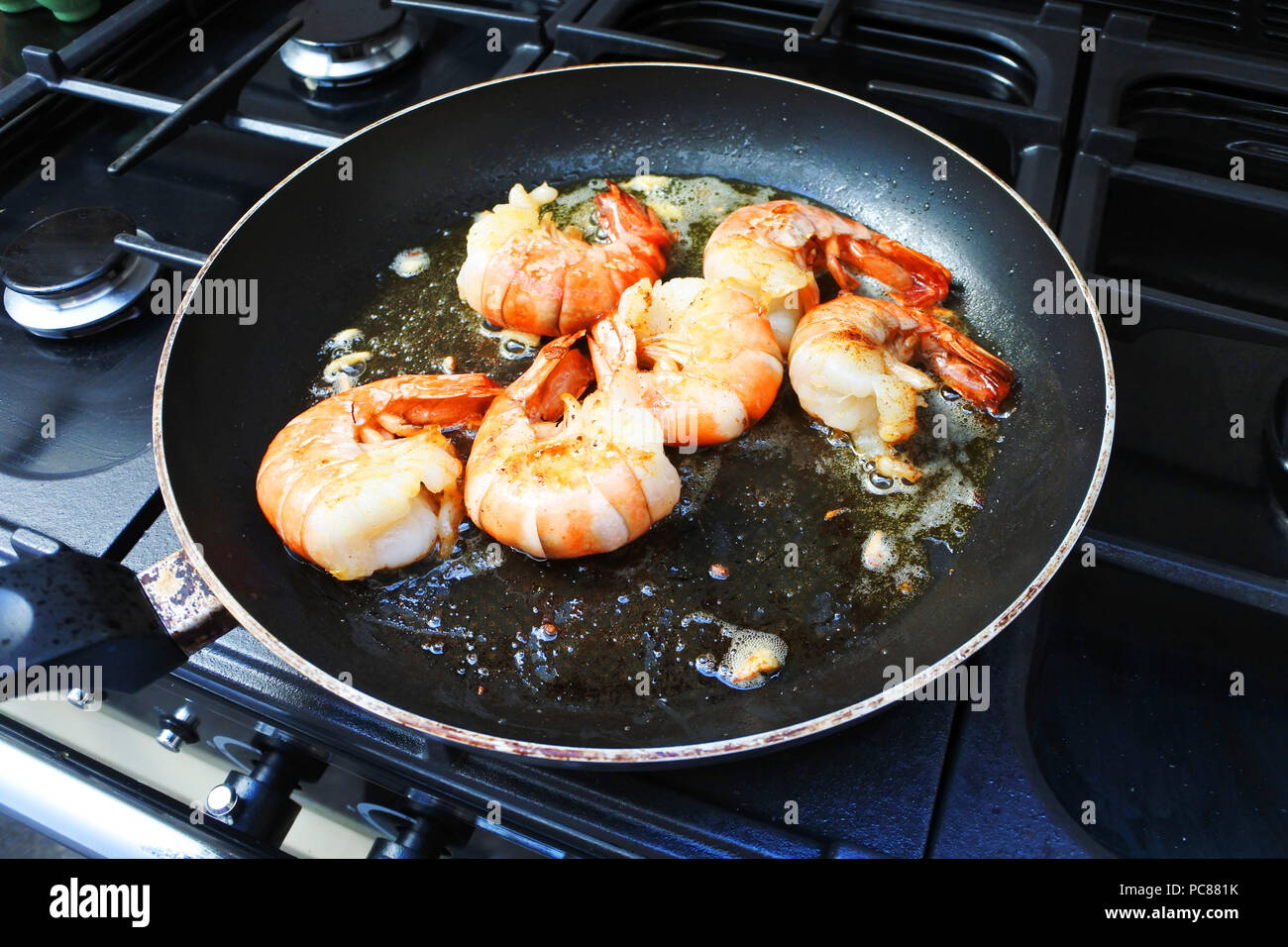 Large tiger prawns frying in garlic butter John Gollop Stock Photo