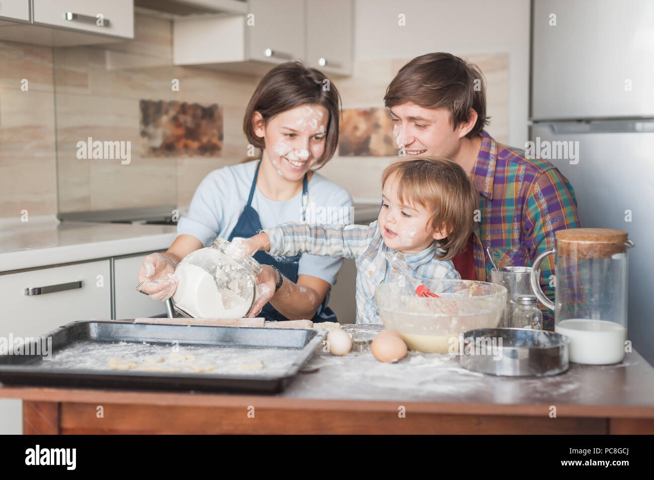 Child Helping In Kitchen little child helping his parents with cooking at kitchen Stock Photo ...