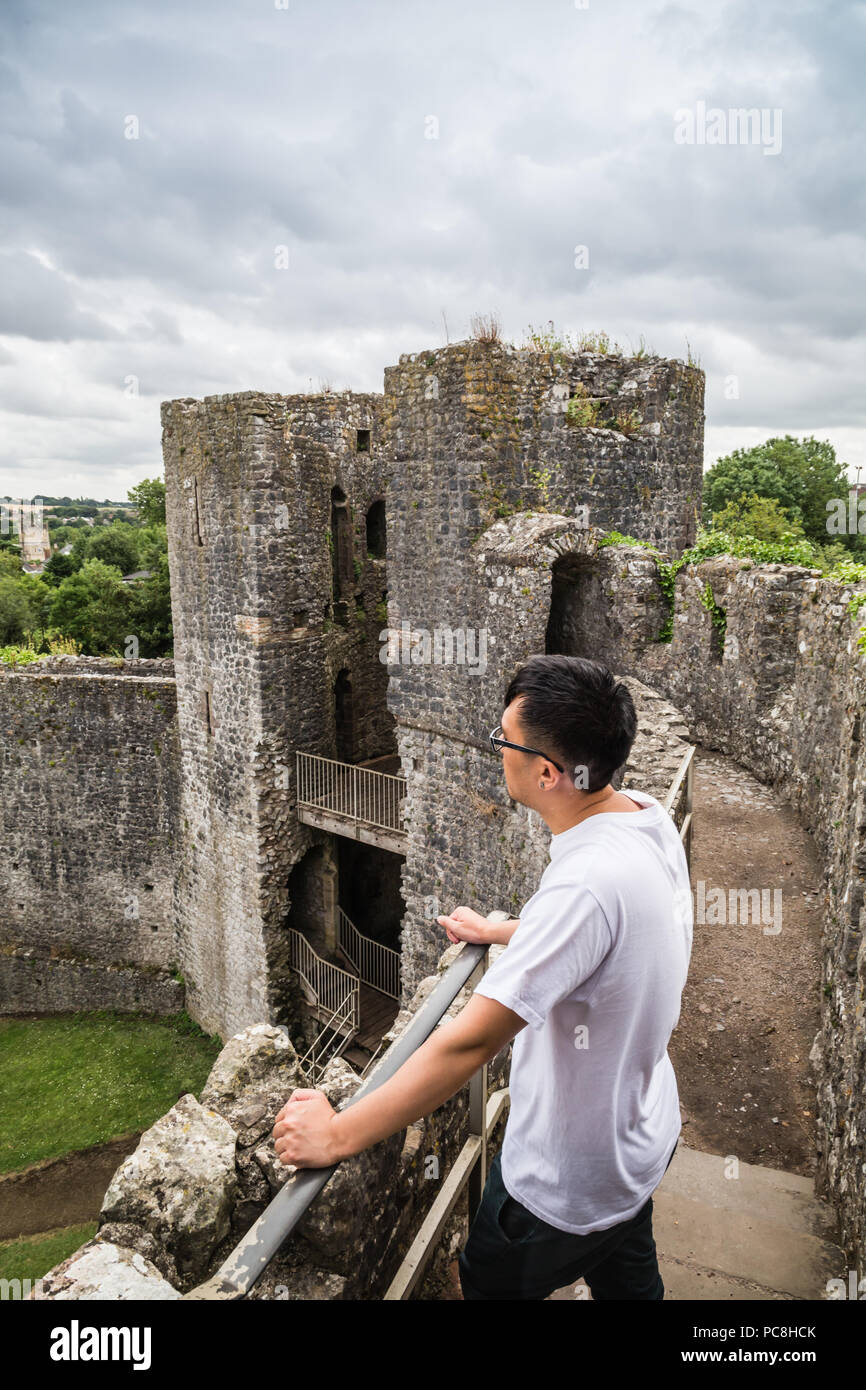 Asian tourist traveling at the oldest surviving post-Roman stone fortification Chepstow Castle (Castell Cas-gwent) at Chepstow, Monmouthshire in Wales Stock Photo