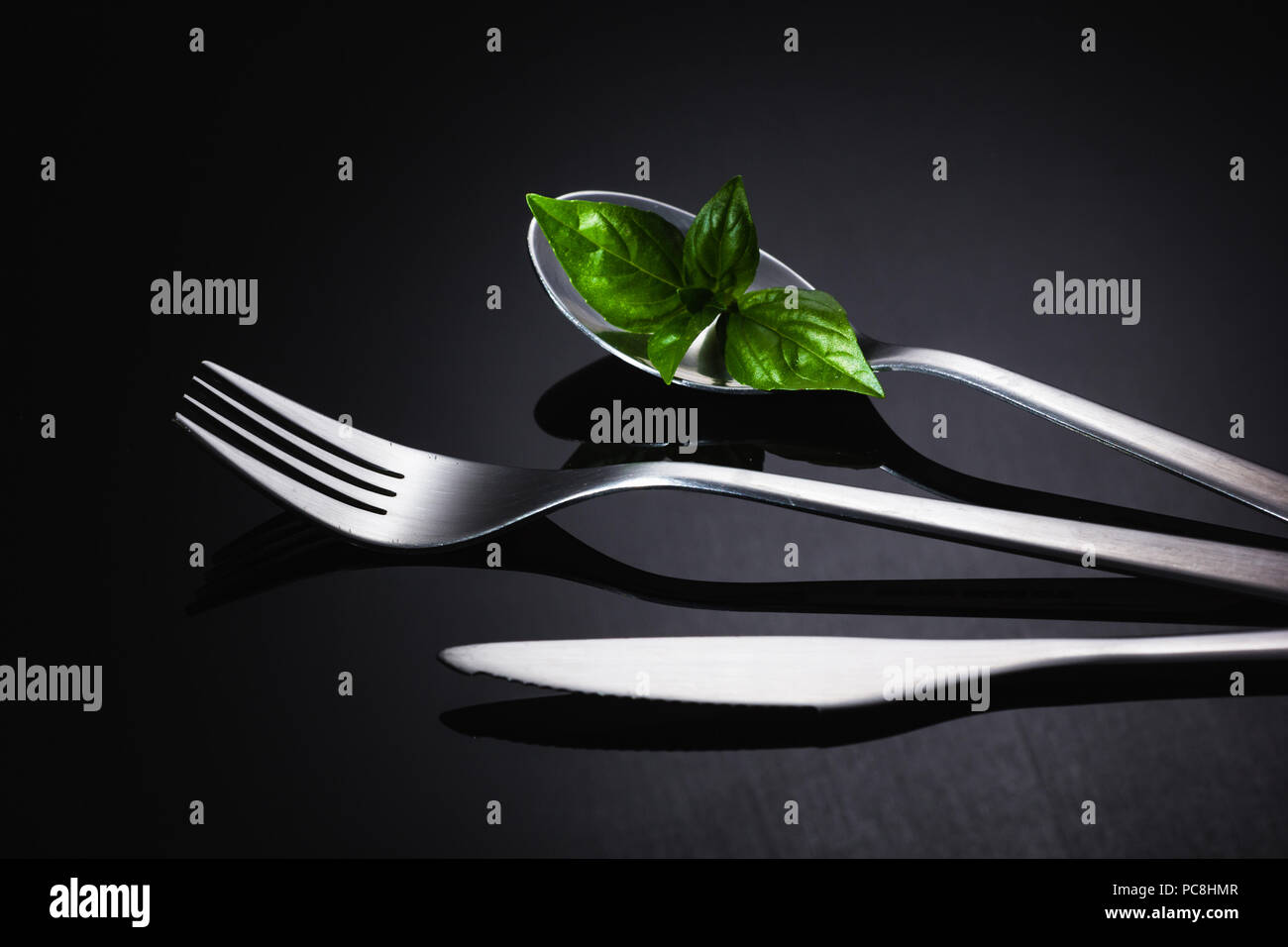 Set of stainless steel cutlery on a black reflective background, Restaurant concept Stock Photo