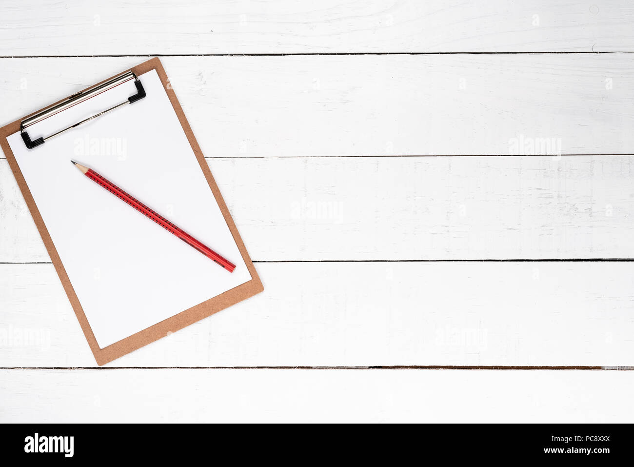 White notepad on red lapis over white wooden background Stock Photo