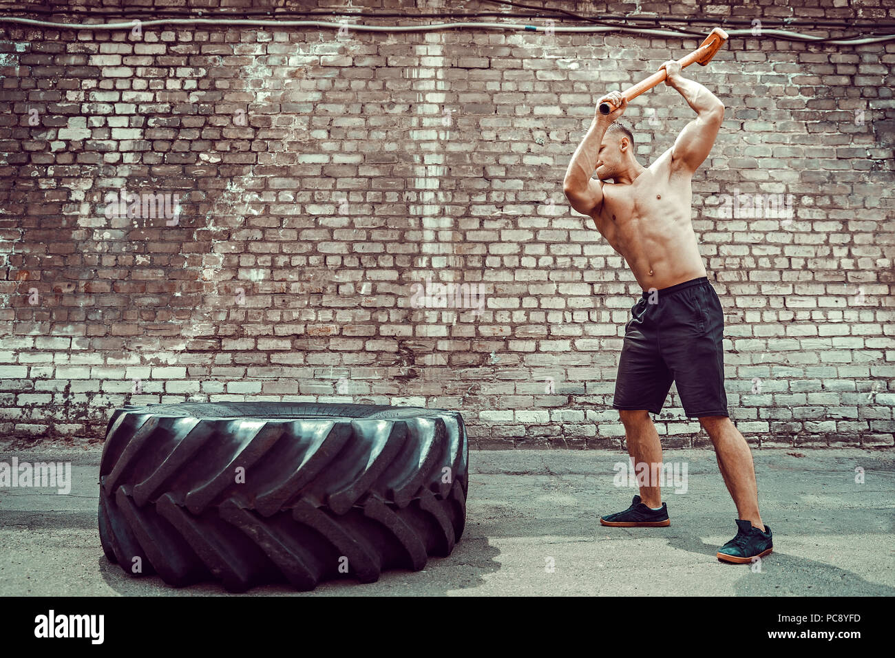 Sport Fitness Man Hitting Wheel Tire With Hammer Sledge Crossfit Training,  Young Healthy Guy Gym Interior OUTSIDE Stock Photo - Alamy