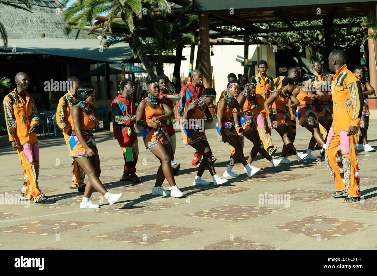 Durban, KwaZulu-Natal, South Africa, young adult Zulu street performers in colourful dress doing synchronised dancing during exhibition Stock Photo