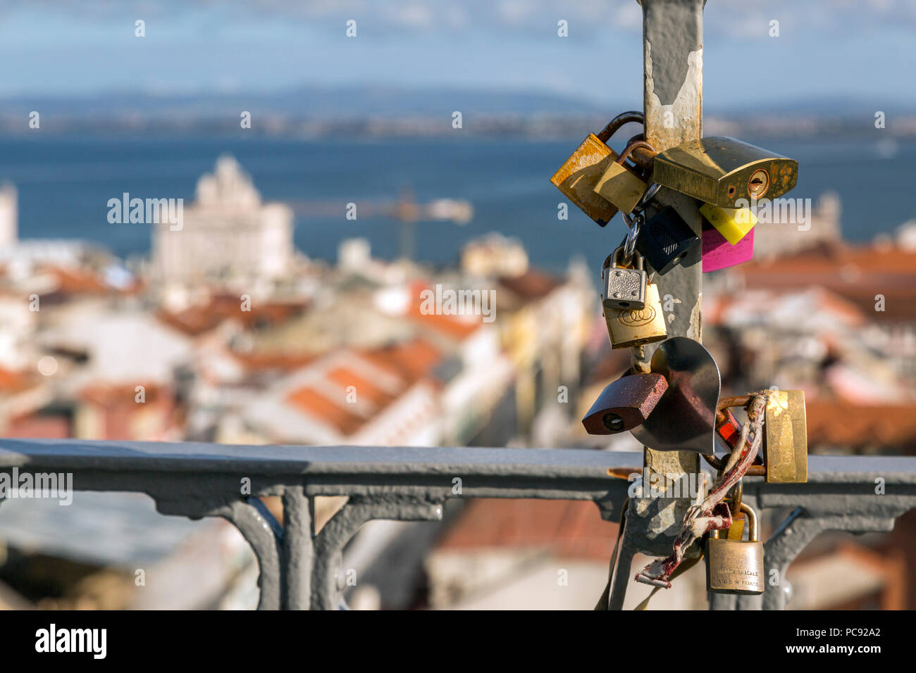 Love locks with city of Lisbon, Portugal beyond , taken on top of the Elevador Santa Justa. Stock Photo