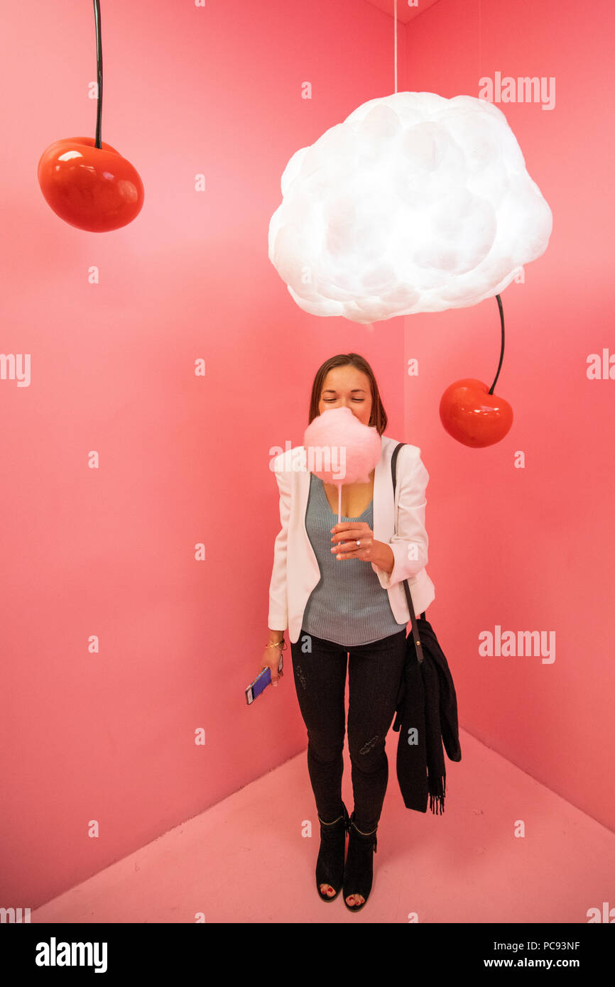 A woman holds her cotton candy surrounded by cherries at the Museum of