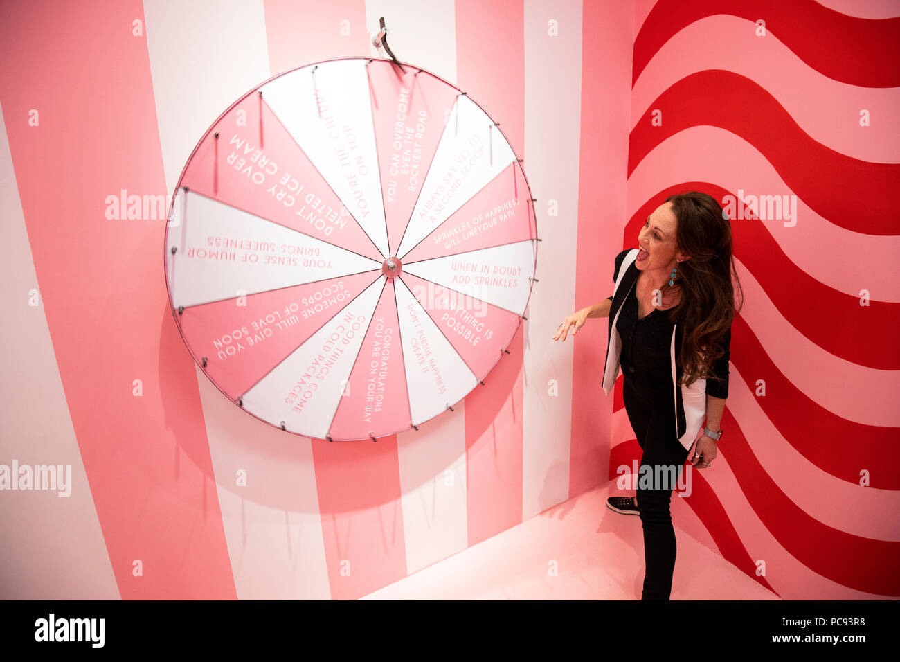 A woman spins a multicolored wheel in the Museum of Ice Cream in San Francisco, California. Stock Photo