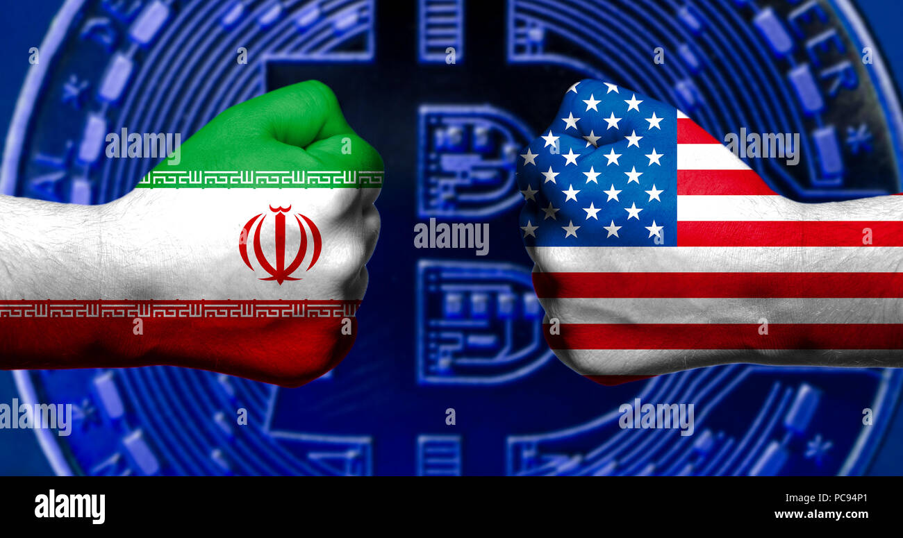 Flags of USA and Iran painted on two clenched fists facing each other with bitcoin in the background/ Iran USA conflict concept Stock Photo