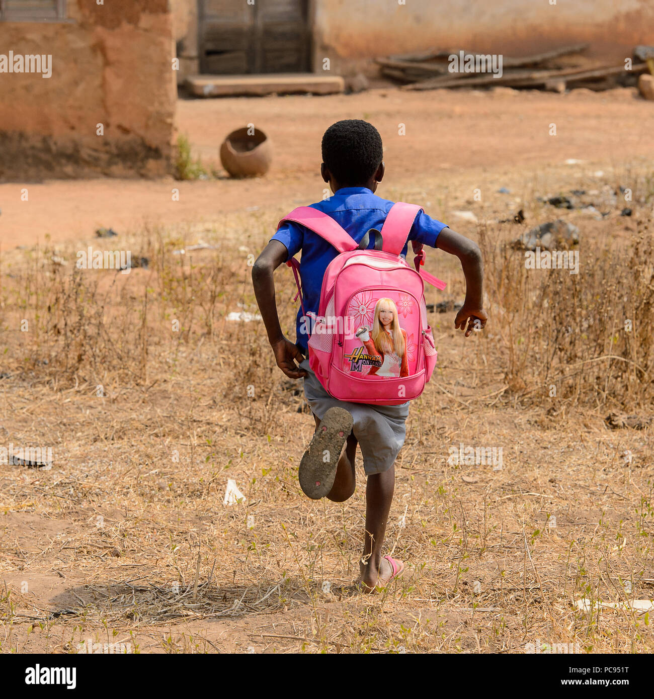 PIRA, BENIN - JAN 12, 2017: Unidentified Beninese little girl in a blue  school uniform with a Hannah Montana backpack runs. Benin kids suffer of  pover Stock Photo - Alamy
